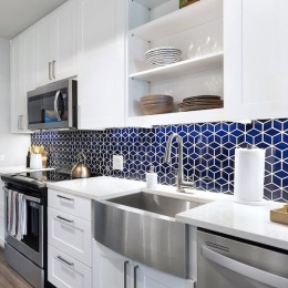 a kitchen with white cabinets and a blue backsplash