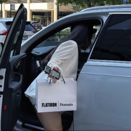 a woman getting into her car with shopping bags